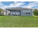 Back exterior featuring a covered patio and a manicured lawn at 15155 Mayberry Dr, Winter Garden, FL 34787