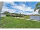 Expansive backyard with lush green lawn, water view, and walking path at 15155 Mayberry Dr, Winter Garden, FL 34787