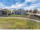 Well-maintained backyard featuring a spacious lawn and a patio with outdoor seating and a manicured landscape at 15155 Mayberry Dr, Winter Garden, FL 34787