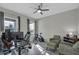Bright home office featuring a modern desk setup, comfortable seating, and natural light from two windows at 15155 Mayberry Dr, Winter Garden, FL 34787