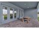 Covered brick patio with multiple access doors and an outdoor dining area at 15155 Mayberry Dr, Winter Garden, FL 34787