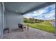 Covered brick patio with serene water views and outdoor dining area at 15155 Mayberry Dr, Winter Garden, FL 34787