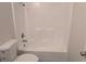 Clean bathroom featuring a toilet and combined shower-tub with a white surround at 19942 Se 155Th Pl, Umatilla, FL 32784