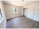 This bedroom features a large window and a spacious closet, as well as gray wood-style floors at 19942 Se 155Th Pl, Umatilla, FL 32784