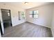 Bedroom featuring neutral walls, gray wood-look flooring, window, and a mirror at 19942 Se 155Th Pl, Umatilla, FL 32784