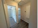 Hallway with doors leading to multiple rooms, showcasing neutral walls and wood floors throughout at 19942 Se 155Th Pl, Umatilla, FL 32784