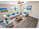 Bright living room with modern gray floors, comfortable furniture, and plenty of natural light at 19942 Se 155Th Pl, Umatilla, FL 32784