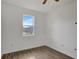 Cozy bedroom featuring wood-look floors, ceiling fan, and a sunny window at 2829 Shelburne Way, St Cloud, FL 34772