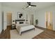 Staged main bedroom with ceiling fan, wood-look flooring, and ensuite bathroom at 2829 Shelburne Way, St Cloud, FL 34772