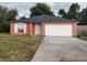 Orange house with white garage door and landscaped lawn at 1009 Fort Smith Blvd, Deltona, FL 32725