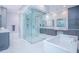 Modern bathroom featuring a glass shower, soaking tub, double vanities, and elegant marble accents at 13779 Abberwick Dr, Orlando, FL 32832