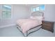 Bedroom featuring a bed with a gray upholstered headboard, a wooden nightstand, and a neutral palette at 13779 Abberwick Dr, Orlando, FL 32832