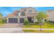 Beautiful two-story home showcasing a well-manicured lawn, elegant stone accents, and a spacious three-car garage at 13779 Abberwick Dr, Orlando, FL 32832