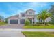 A beautiful two-story home with a manicured lawn, a three-car garage and stone accents at 13779 Abberwick Dr, Orlando, FL 32832