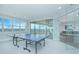 Bright game room features a ping pong table, glass doors, and beautiful views from large windows at 13779 Abberwick Dr, Orlando, FL 32832