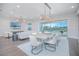 A spacious living and dining area features stylish decor, hardwood floors, and large windows offering scenic views and ample natural light at 13779 Abberwick Dr, Orlando, FL 32832
