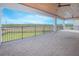 Large covered patio with brick pavers overlooking a green lawn and a natural wooded area at 13779 Abberwick Dr, Orlando, FL 32832