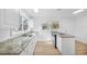 Bright kitchen features white cabinets, granite countertops, stainless sink, and appliances with new flooring at 514 S 7Th St, Lake Wales, FL 33853