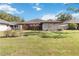 View of the home's back exterior and expansive lawn, offering a private outdoor space at 7 Huntley Ct., Haines City, FL 33844