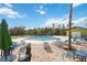 Community pool area surrounded by lounge chairs and lush landscaping under a sunny sky at 7 Huntley Ct., Haines City, FL 33844
