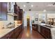 Modern kitchen featuring dark wood cabinets, granite counters, and ample storage at 25859 Crossings Bluff Ln, Sorrento, FL 32776