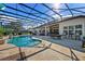 Enjoy this covered patio with a pool, seating, and pool table at 25859 Crossings Bluff Ln, Sorrento, FL 32776