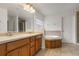 Bright bathroom with double vanity, large mirror, soaking tub, and ceramic tile floors at 2806 Balforn Tower Way, Winter Garden, FL 34787