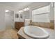Bright bathroom featuring a soaking tub, double vanity, and walk-in closet at 2806 Balforn Tower Way, Winter Garden, FL 34787
