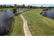 Scenic view of a golf course with lush green grass and a path alongside a calm lake at 2806 Balforn Tower Way, Winter Garden, FL 34787