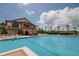 A stunning pool view by clubhouse featuring ample deck space, lounge chairs, and mature palm trees at 2806 Balforn Tower Way, Winter Garden, FL 34787