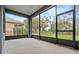 View of screened patio with ceiling fan and exterior view of the yard and greenery at 2806 Balforn Tower Way, Winter Garden, FL 34787