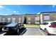 Exterior shot of an apartment complex with a parking lot including multiple vehicles at 5317 Curry Ford Rd # J101, Orlando, FL 32812