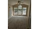 An empty bedroom features three large windows with a vaulted ceiling and neutral-colored carpet at 821 Veranda Pl, Celebration, FL 34747