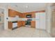 Galley kitchen with wood cabinets, stainless steel appliances, and tiled floor at 113 Kristi Ann Ct # 113, Winter Springs, FL 32708