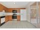 Galley kitchen with wood cabinets, stainless steel appliances, and tiled floor at 113 Kristi Ann Ct # 113, Winter Springs, FL 32708