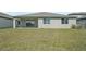 View of a spacious backyard with sliding glass doors leading to a covered patio at 2316 Citrus Bloom Dr, Bartow, FL 33830