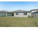 View of a home's backyard featuring a covered patio and lush green lawn at 2316 Citrus Bloom Dr, Bartow, FL 33830