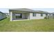 Spacious backyard with well-maintained lawn, covered patio, and partial fencing, ideal for outdoor activities at 2316 Citrus Bloom Dr, Bartow, FL 33830