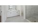 Modern bathroom with double vanity, sleek gray tile flooring, and glass enclosed shower at 2316 Citrus Bloom Dr, Bartow, FL 33830