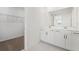 Bathroom with double vanity sinks, a large mirror, and a door leading to the walk-in closet at 2316 Citrus Bloom Dr, Bartow, FL 33830