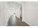 Bright hallway featuring sleek wood-look tiling, fresh white walls, and inviting doorways leading to various rooms at 2316 Citrus Bloom Dr, Bartow, FL 33830