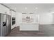 Stylish kitchen with stainless steel appliances, quartz countertops, white shaker cabinets, and gray wood-look floors at 2316 Citrus Bloom Dr, Bartow, FL 33830