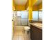 A bathroom with yellow walls, a shower/tub combo, and wood vanity at 2485 Huron Cir, Kissimmee, FL 34746