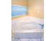 A corner bathtub with white tile surround in a small bathroom at 2485 Huron Cir, Kissimmee, FL 34746