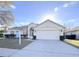 Single-story house with a two-car garage, landscaping, and a For Sale sign at 2485 Huron Cir, Kissimmee, FL 34746