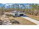 Charming single-story home featuring a white exterior, dark garage door, and a well-manicured lawn surrounded by tall trees at 406 Nw Narcissus Rd, Dunnellon, FL 34431