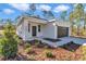 Inviting front entrance featuring a covered porch, contemporary door, stylish plants, and welcoming pathway at 406 Nw Narcissus Rd, Dunnellon, FL 34431