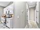 Hallway with kitchen featuring white cabinetry, stainless steel appliances, and access to other rooms at 406 Nw Narcissus Rd, Dunnellon, FL 34431