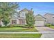Two-story house with stone accents and a landscaped lawn at 14157 Creekbed Cir, Winter Garden, FL 34787