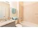 Bright bathroom featuring a vanity with granite countertops and a shower-tub combination at 1788 Coriander Dr, Kissimmee, FL 34759